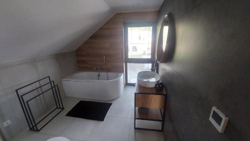 bagno con vasca bianca e lavandino di Chalet Prestige a Valča