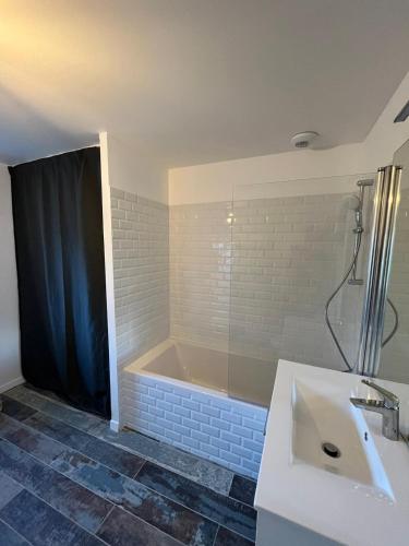 a bathroom with a sink and a bath tub at Modern country house near Fontainebleau in Samoreau