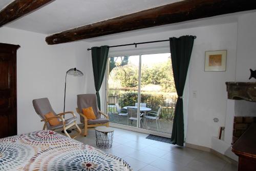een slaapkamer met een bed en een balkon met een tafel en stoelen bij Gites Provence et Nature - séjours de rêve entre Luberon et Monts de Vaucluse in Cabrières-dʼAvignon