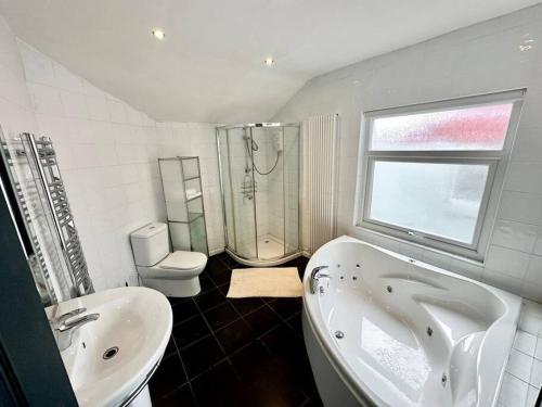 y baño con bañera, lavabo y aseo. en Liverpool Getaway Home! en Liverpool