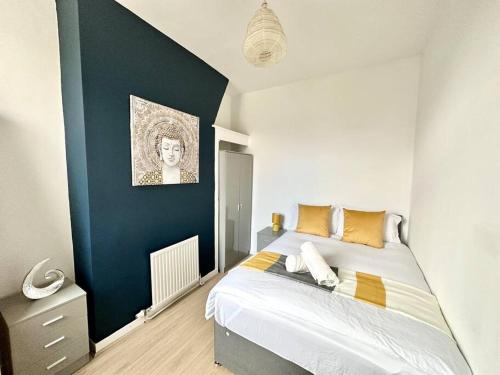 a bedroom with a bed with a blue accent wall at Liverpool Getaway Home! in Liverpool