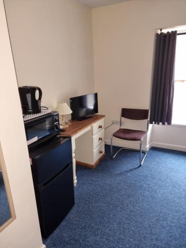 a room with a desk with a computer and a chair at Kings Arms Guest House Ebbw Vale in Ebbw Vale