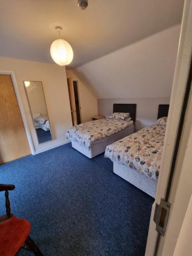 a bedroom with two beds and a mirror at Kings Arms Hotel Ebbw Vale in Ebbw Vale