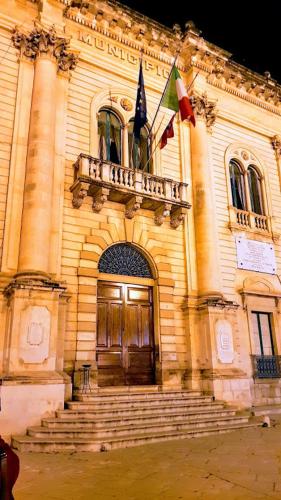 a building with a balcony and a door with two flags at Casa Vacanze La Fenice - Casa Atlantica in Cava dʼAliga