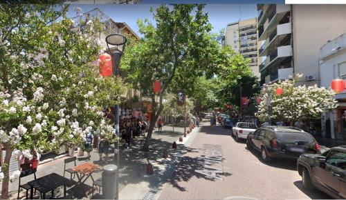 una calle de la ciudad con árboles y coches aparcados en la carretera en Beños en Buenos Aires