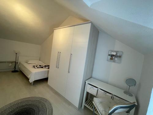 a bedroom with a white cabinet and a bed at Jacuzzi apartman Marin in Bol