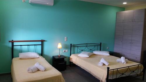 Agia Kiriaki Bungalows في اليكاناس: سريرين في غرفة ذات جدار أزرق