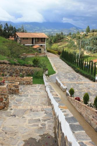 un chemin en pierre avec une maison en arrière-plan dans l'établissement Villa Germana, à Paipa