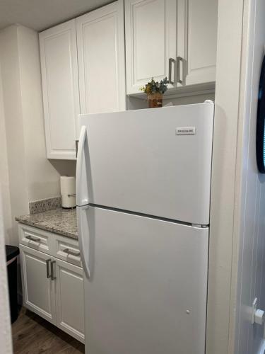 a white refrigerator in a kitchen with white cabinets at Beautiful renovated Studio Apartment in Gadsden AL in Gadsden