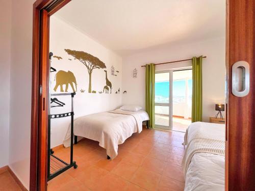 a bedroom with two beds and a window at Private Villa Rego with Oceanview and Pool in Luz