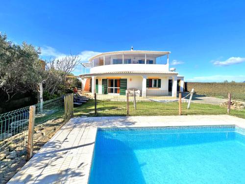 a house with a swimming pool in front of a house at Private Villa Rego with Oceanview and Pool in Luz