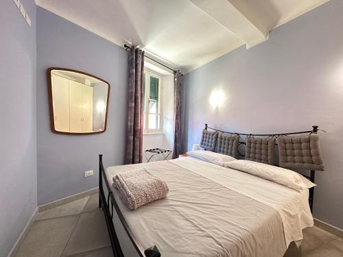 een slaapkamer met een groot bed met een spiegel aan de muur bij Appartamenti a Cà Mia in La Spezia