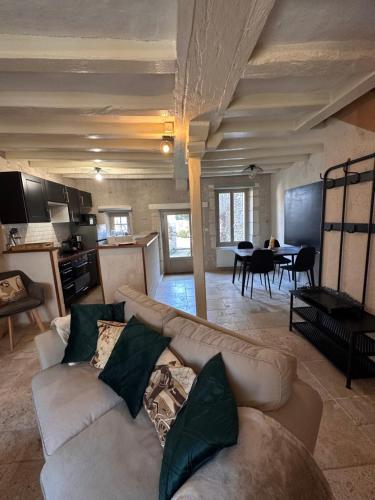 a living room with a couch and a dining room at Le Lavoir aux Roses by Gîtes Sud Touraine in Chédigny