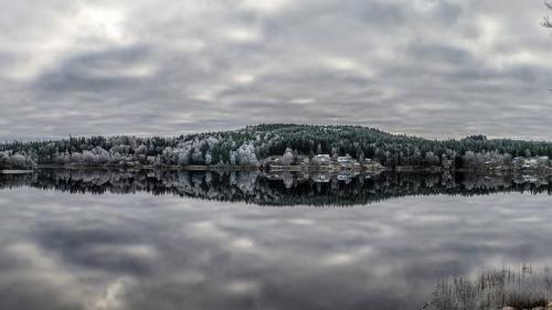 a view of a lake with trees and houses at Évika boutique hotel in Eskilsby