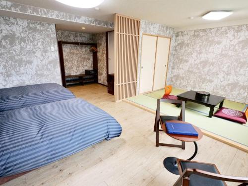 Apprising hotels GranJam Tsugaike - Vacation STAY 77381v في Chikuni: غرفة نوم بسرير ومكتب وطاولة
