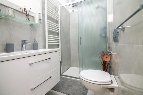 e bagno con doccia, servizi igienici e lavandino. di Apartments Kinkela a Opatija