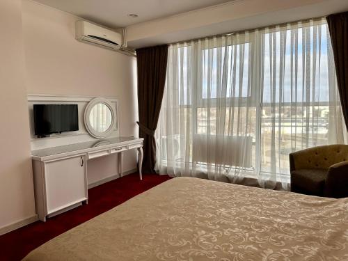 Mark Plaza Hotel في نيكولايف: غرفه فندقيه سرير وتلفزيون