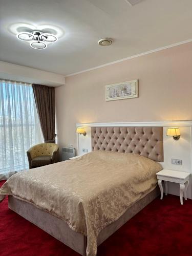a bedroom with a large bed and a large window at Mark Plaza Hotel in Mykolaiv