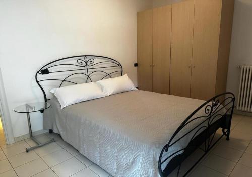 a bedroom with a bed with a white pillow and a table at Residence La Settima in Milano Marittima