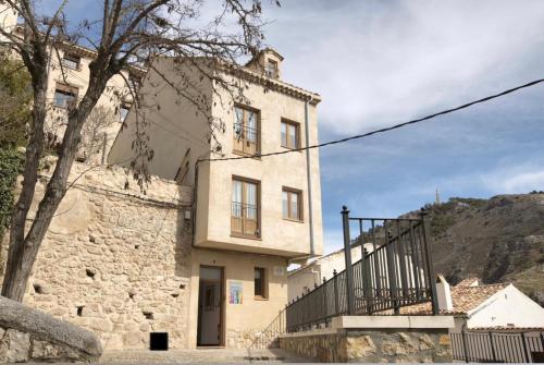 un edificio de piedra con una escalera delante en Cuencaloft Matadero viejo en Cuenca