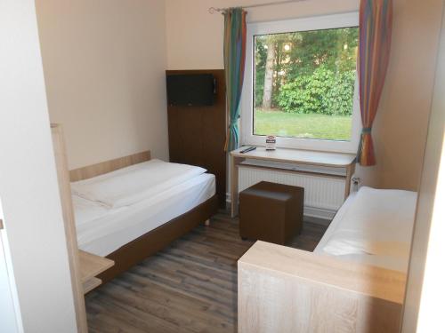 Habitación pequeña con 2 camas y ventana en Hotel-Restaurant Tüxen, en Rendsburg