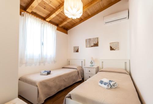 una camera con due letti e una finestra di Case Vacanze la fenice- Casa Mediterranea a Cava dʼAliga