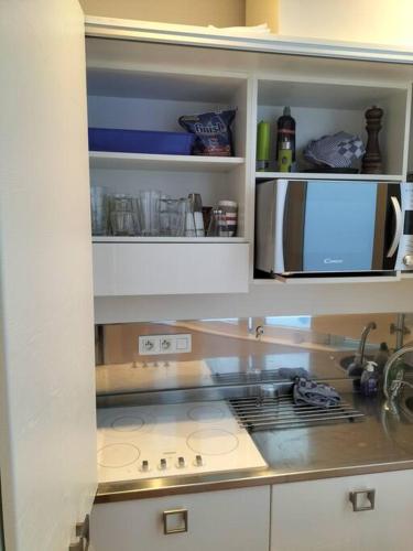 eine Küche mit einem Herd und einer Mikrowelle in der Unterkunft Appartement - Quartier européen in Brüssel