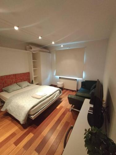 ein Schlafzimmer mit einem Bett, einem Sofa und einem Stuhl in der Unterkunft Appartement - Quartier européen in Brüssel
