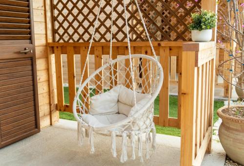a white chair hanging from a pergola at Case Vacanze la fenice- Casa Mediterranea in Cava dʼAliga
