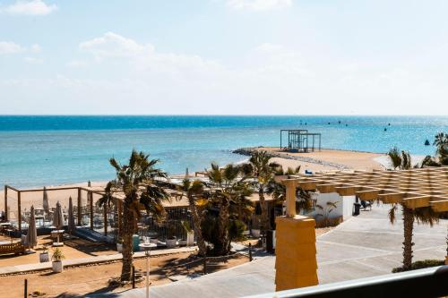 a view of a beach with palm trees and the ocean at El Gouna Elite Worldwide Sea & Garden Residences - Hurghada, Egypt in Hurghada