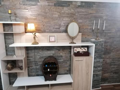 a room with a fireplace with a mirror on a wall at Apartman Dionis SM in Sremska Mitrovica