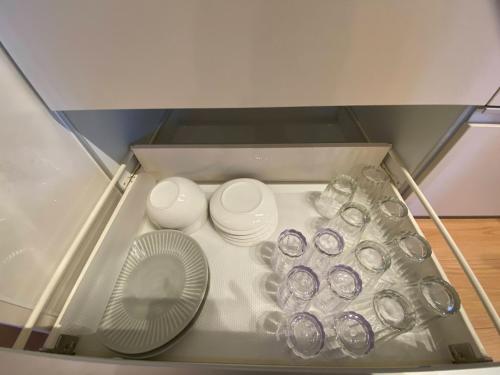 un tiroir rempli de verres et d'assiettes ainsi qu'un ventilateur dans l'établissement Airport Kikuyo Forest - Vacation STAY 14128, à Kikuyo
