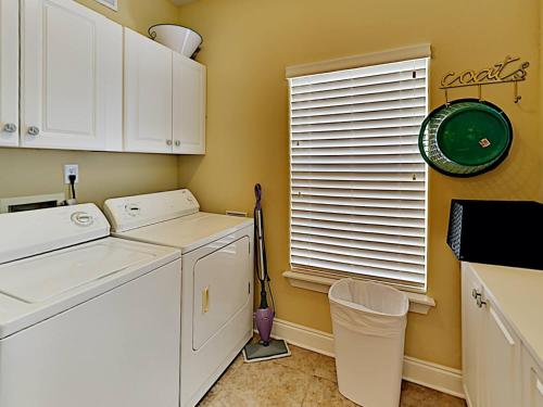 Un lavadero con electrodomésticos blancos y una ventana. en Banana Bay Townhome #6075, en Perdido Key