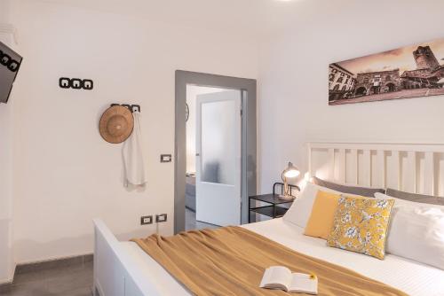 - une chambre avec un lit et un livre dans l'établissement DOMUSBERGAMO - Bon bon Apartment, à Bergame