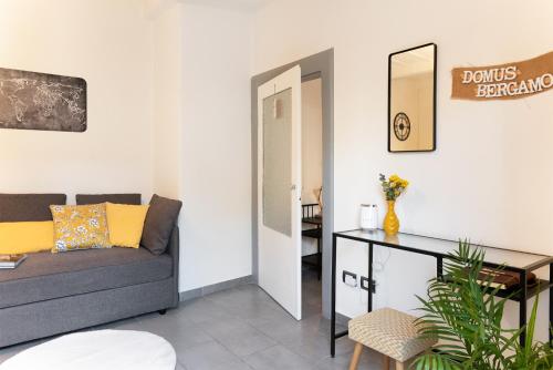 - un salon avec un canapé et une table dans l'établissement DOMUSBERGAMO - Bon bon Apartment, à Bergame