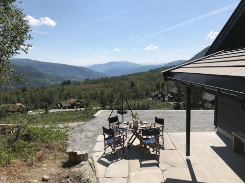 una mesa y sillas en un patio con vistas en Grand and modern cabin en Sogndal