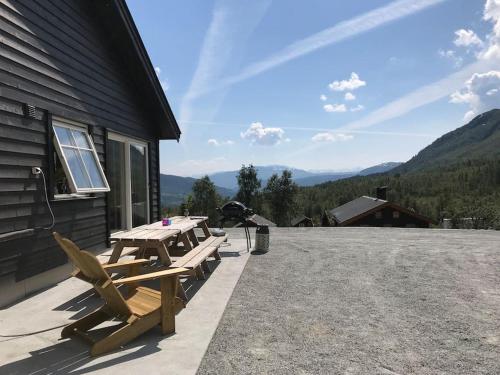 a picnic table and chairs on the side of a building at Grand and modern cabin in Sogndal
