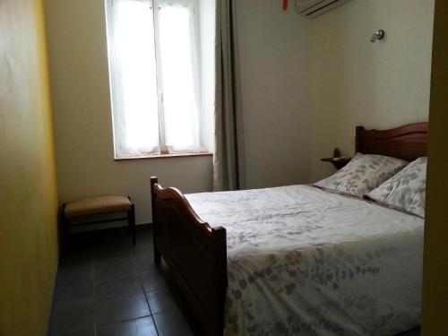 1 dormitorio con cama y ventana en Millot Conilhac, en Conilhac-Corbières