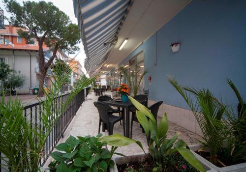 d'un balcon avec une table, des chaises et des plantes. dans l'établissement HOTEL BLUE SKY, à Rimini