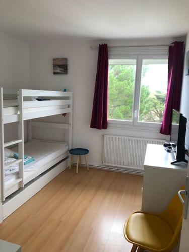 une chambre avec un lit, un bureau et une fenêtre dans l'établissement Bel appartement 60m2 vue mer La Baule Escoublac, à La Baule