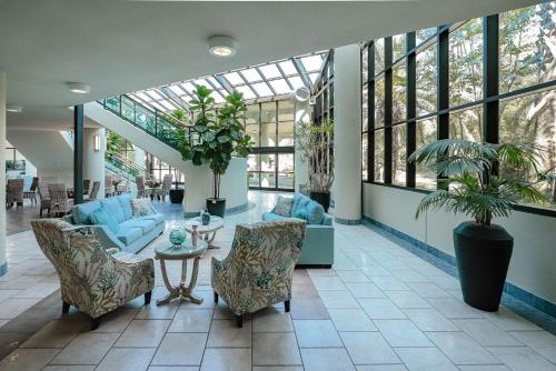 Un vestíbulo con sillas y una mesa en un edificio. en Phoenix on the Bay by Brett Robinson Vacations, en Orange Beach