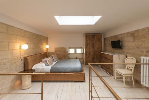 una camera con letto, scrivania e TV di Le Nicchie luxury rooms a Lecce