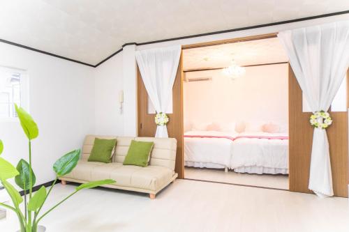 9 min to Yokkaichi Tomida STN House - Vacation STAY 14165 في يوكايتشي: غرفة نوم مع مرآة وأريكة وسرير