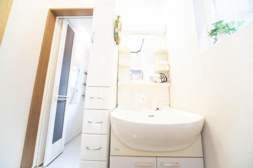 een badkamer met een wastafel en een spiegel bij 9 min to Yokkaichi Tomida STN House - Vacation STAY 14165 in Yokkaichi