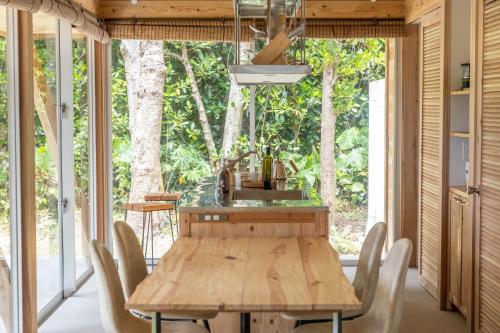 a dining room with a wooden table and chairs at SHINMINKA Villa JANADO - Vacation STAY 66320v in Kumejima
