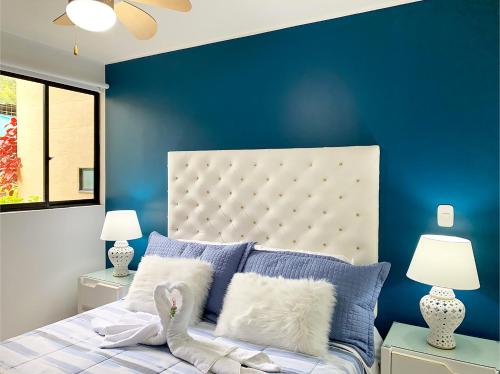een slaapkamer met een blauwe accentmuur en een bed bij Apartamento en el Eje Cafetero Quindio con piscina jacuzzi wifi in La Tebaida