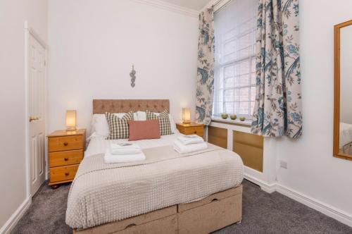 a bedroom with a large bed and a window at Shambles Suites in the centre of York, sleeps 16 in York