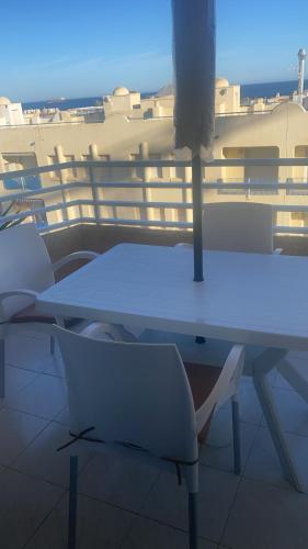 - Balcón con mesa blanca y sillas en Apartamento Andalucía - vistas al mar, playa, puerto deportivo, garaje, en Garrucha