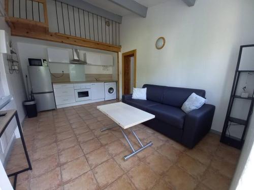 sala de estar con sofá y mesa en Rez de villa à la campagne, en Le Luc