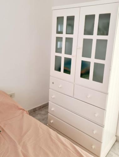 1 dormitorio con cómoda blanca en Dpto Live en Caleta Olivia